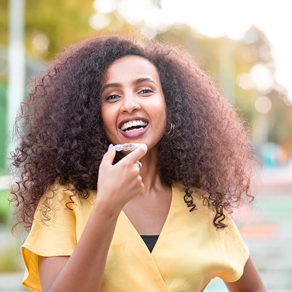 Woman Smiling Outdoors with Clear Aligner